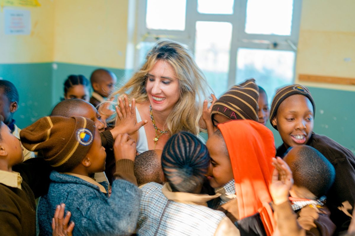 A volunteer laughing together with students in a classroom in Tanzania